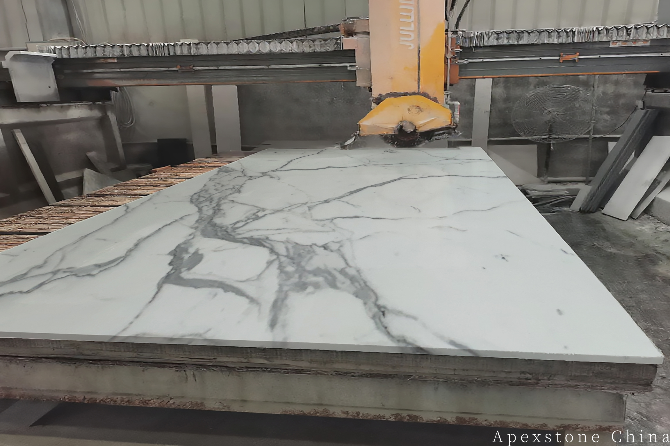 Calacatta White countertop slab cutting on a bridge saw