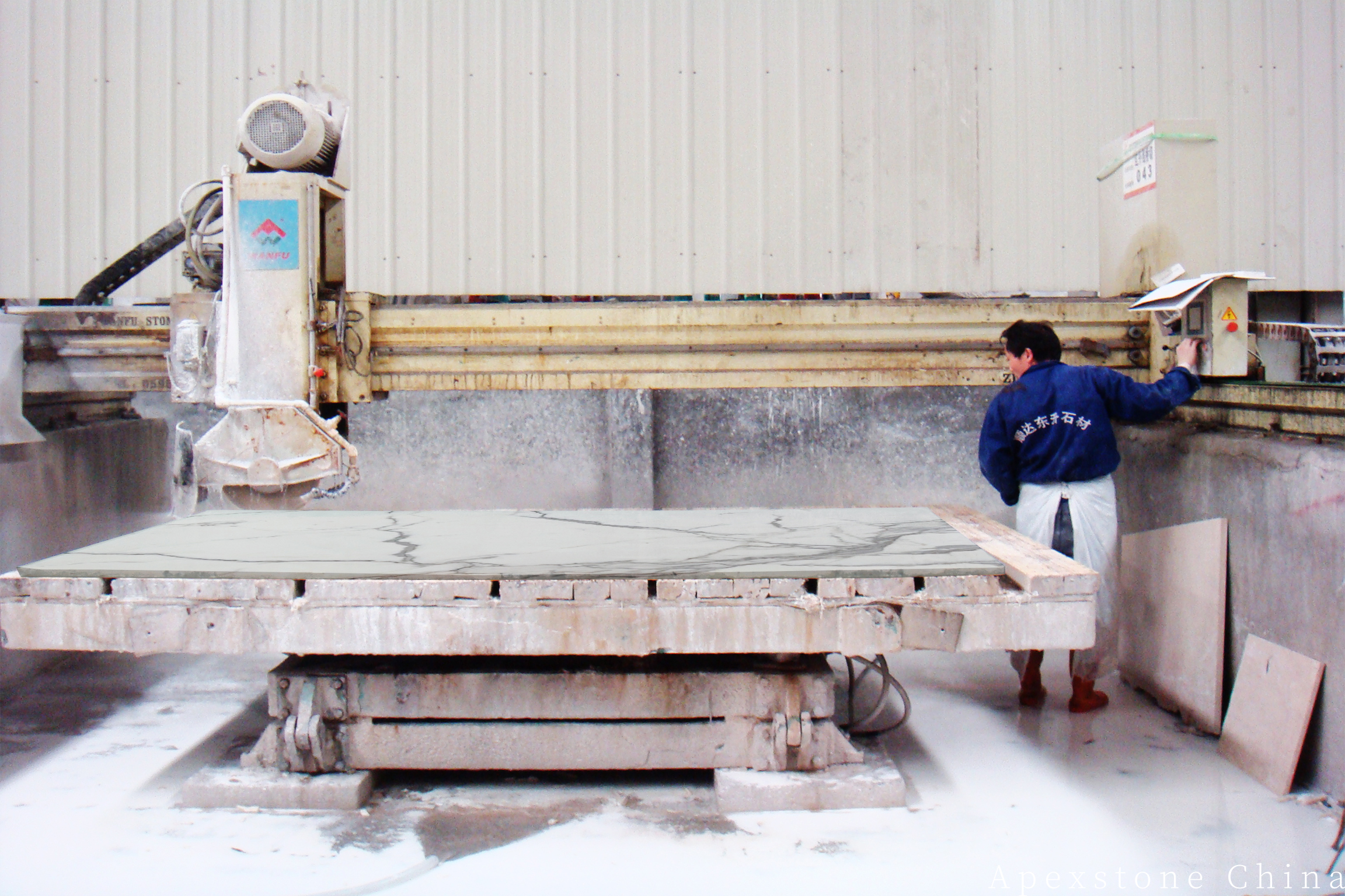 Calacatta White slabs being trimmed on a bridge saw